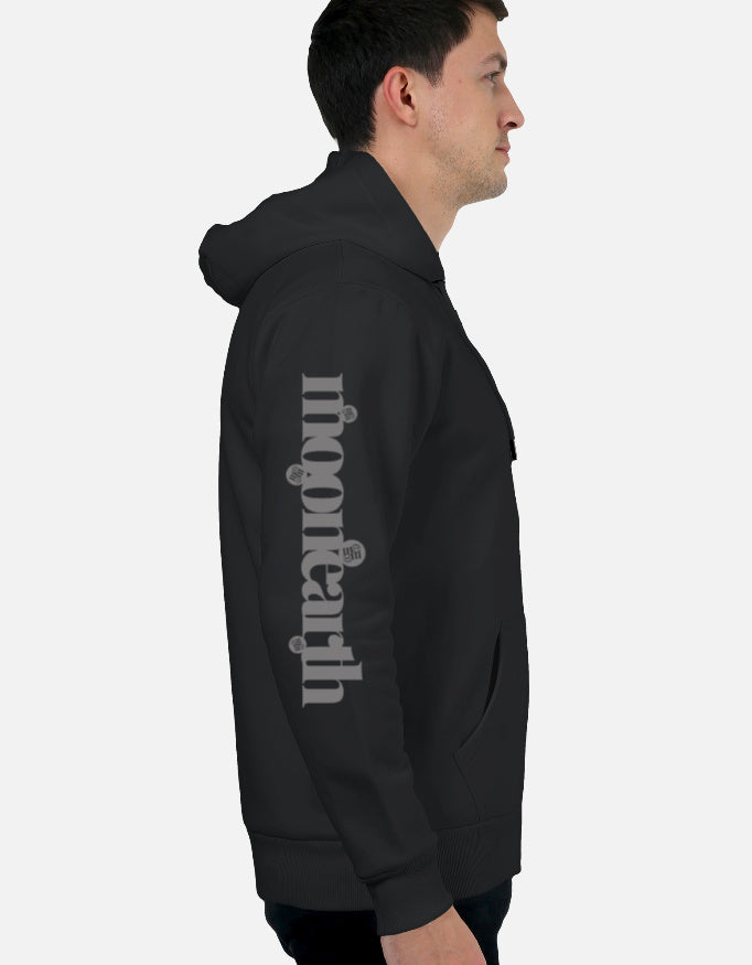 Person wearing a black moonearth hoodie with text on the sleeve against a light gray background
