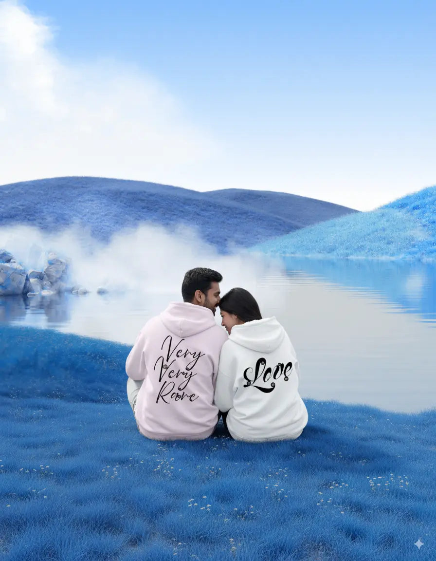 Two people sitting on a blue grass field wearing moonearth hoodies with text.